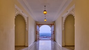 A corridor with ornate arches and a view of the landscape.