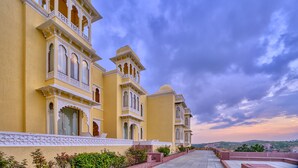 A traditional yellow building with ornate balconies and a clear sky.