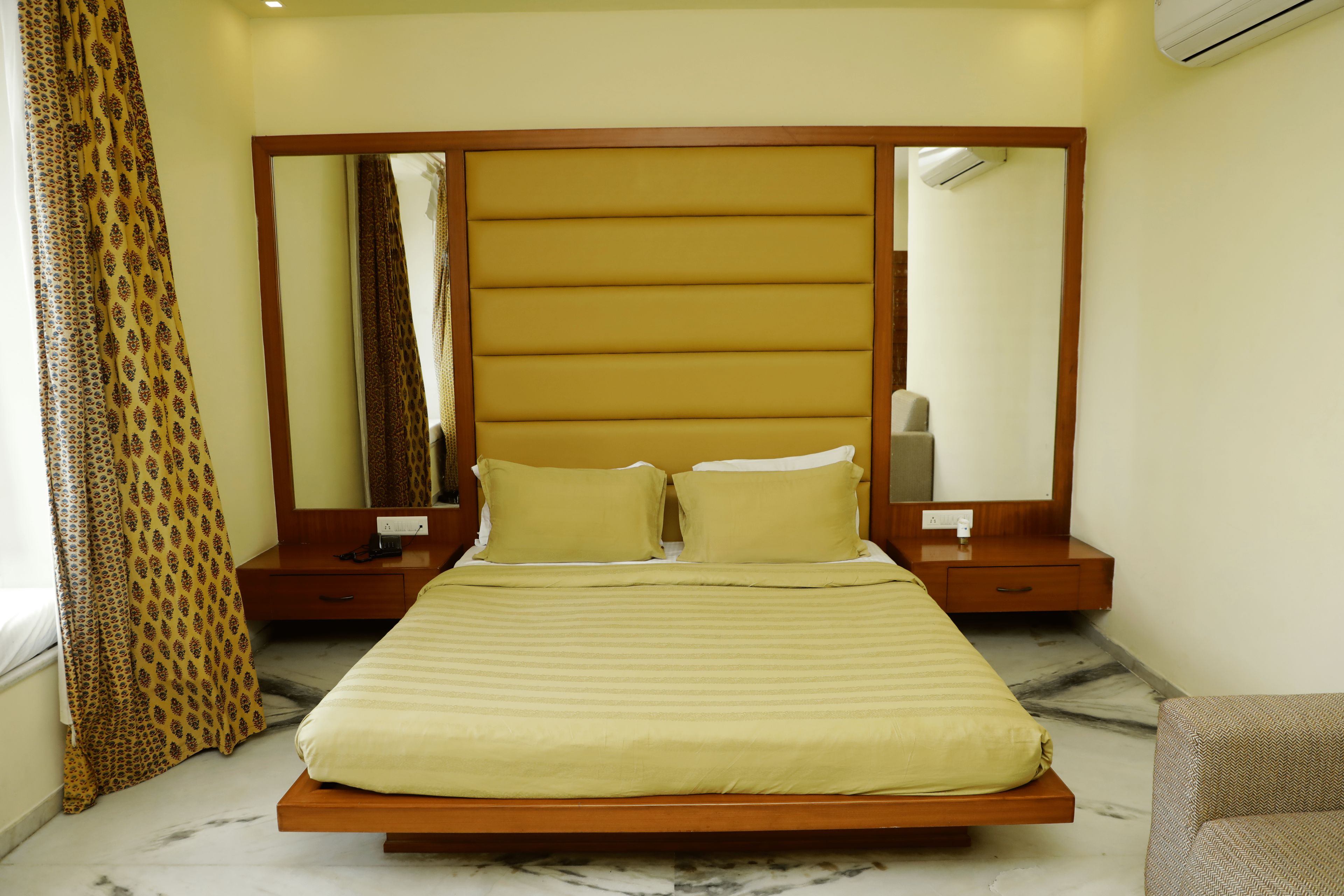 A bed with a headboard, bedside tables, and a mirror.