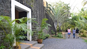 Une cour avec un chemin de gravier, des plantes en pot et un mur de briques.