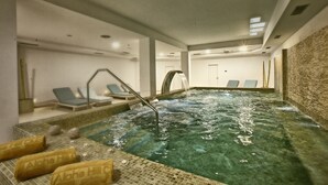 Un'area benessere con vasca idromassaggio, poltrone relax e asciugamani.