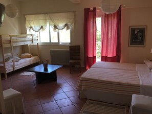 A room with bunk beds, a small table, a chair, and a radiator. - Rex Hotel (Zacharo)