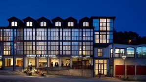 Un hôtel à étages, doté de grandes fenêtres et d’une enseigne indiquant « ABRIGO DA MONTANHA ».