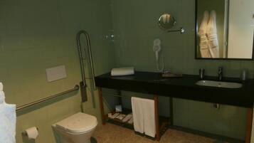 A bathroom with a toilet, sink, and mirror.