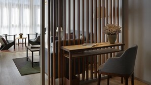 Un salon moderne avec un séparateur en bois, une table à manger avec des chaises et une plante en pot.