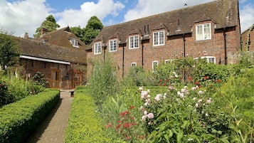 A traditional brick house with a garden pathway leading to the entrance.