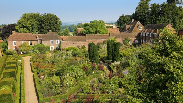 A traditional brick house with a garden pathway leading to the entrance. - The Stable Courtyard Bedrooms at Leeds Castle (Maidstone)
