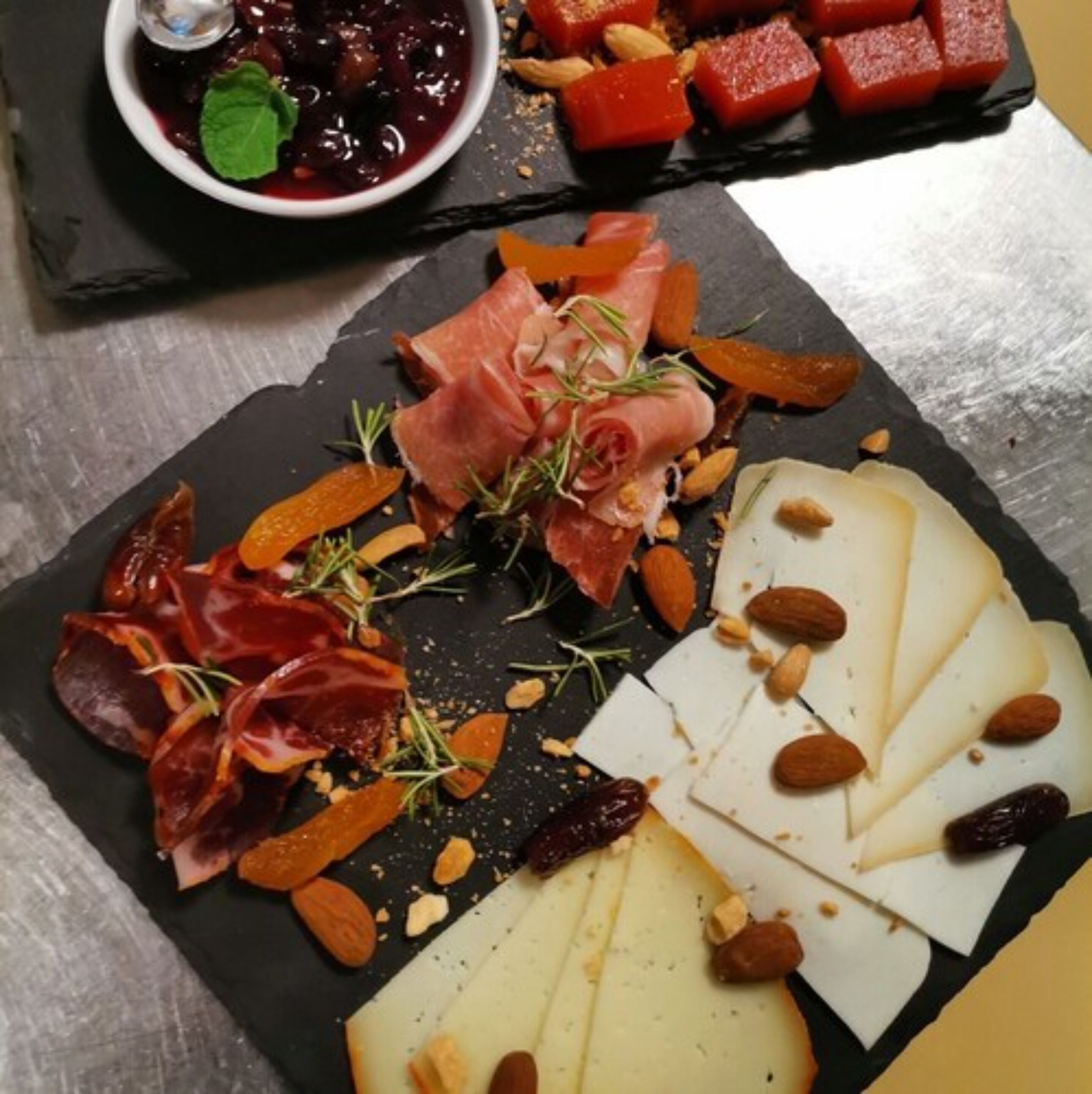 A charcuterie board with various meats, cheeses, and nuts.