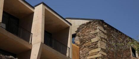 A modern building with a stone facade and balconies.