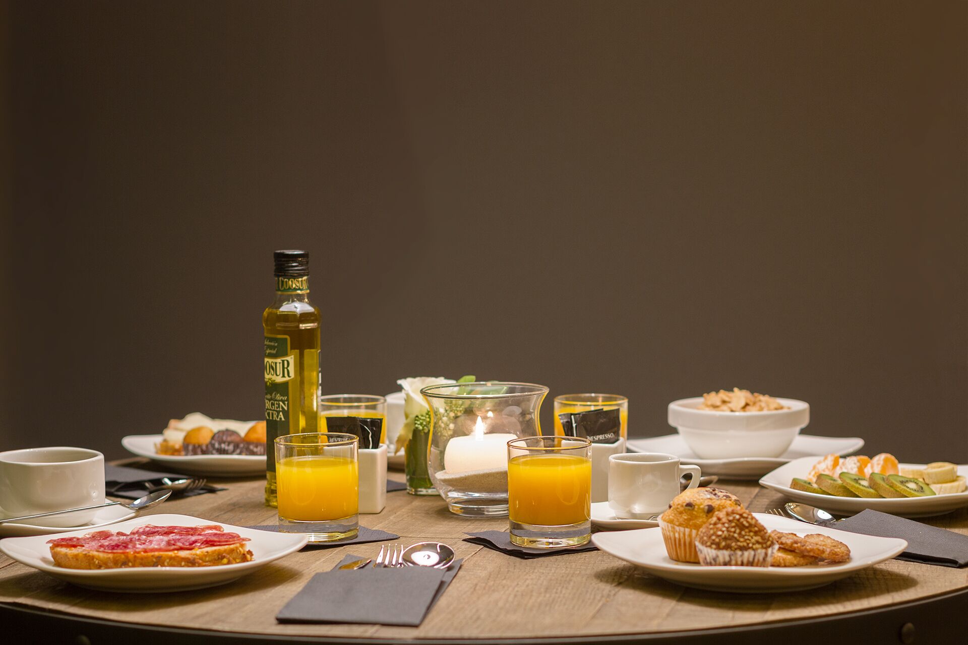 A breakfast setting with a bottle, glasses, and plates of food.