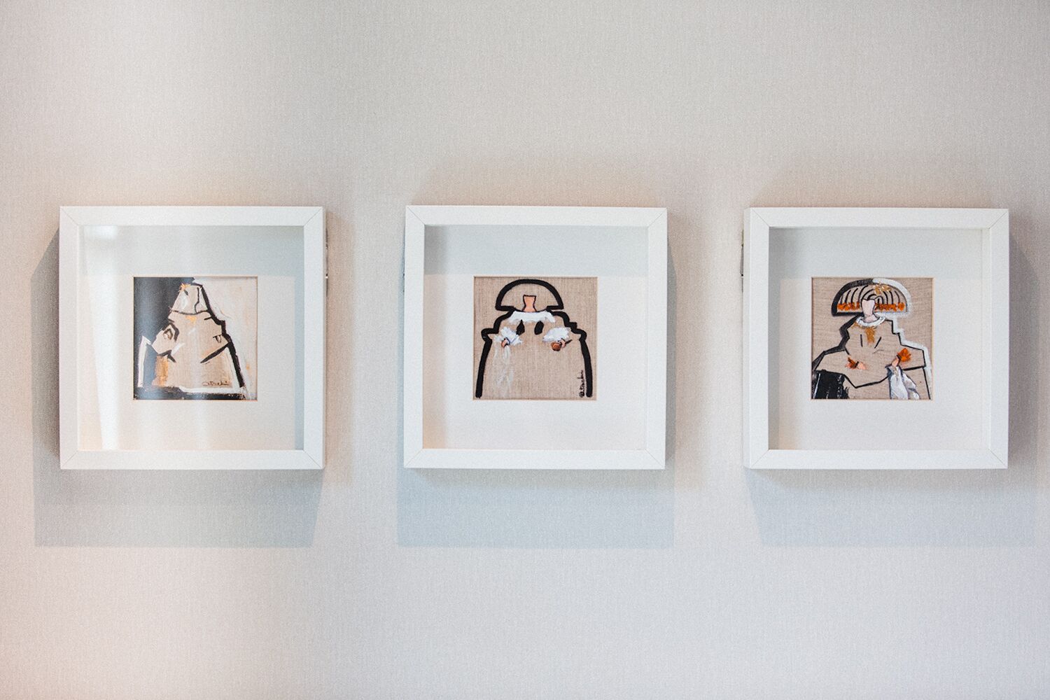 Three framed artworks on a wall.