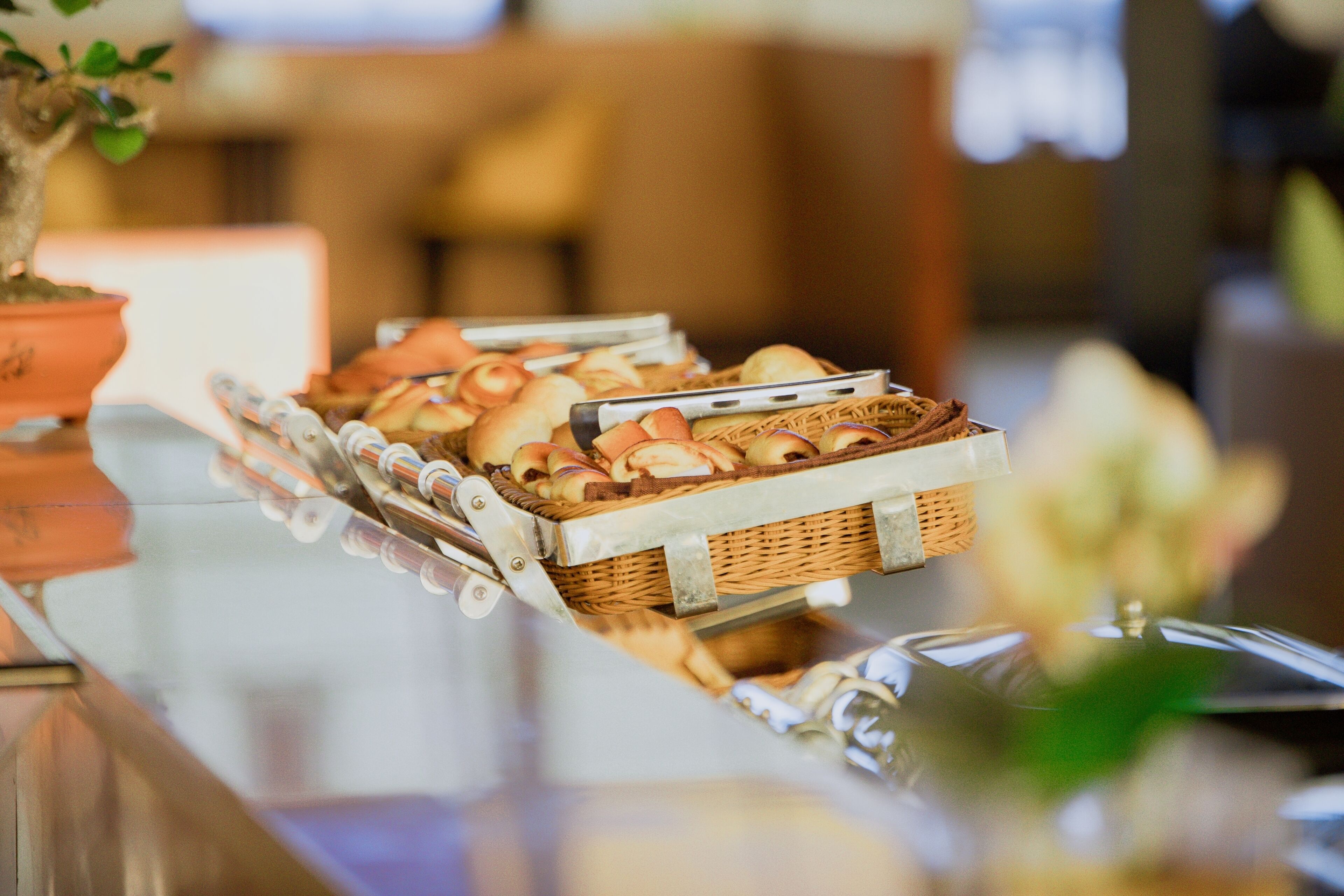 A buffet table with various baked goods and a potted plant.