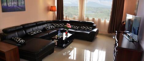 A modern living room with a sectional sofa, a coffee table, and a television.