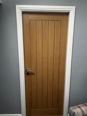 A closed wooden door with a number '1' on it, white trim, and a metal handle. - Chevin End Guest House (Ilkley)