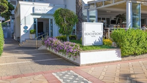 A hotel entrance with a sign, steps, and a landscaped area with plants. - The Beachfront Hotel Adult Only 16 Plus (Marmaris)