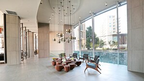 Un hall espacioso con mobiliario moderno, ventanas amplias y vistas a la ciudad.