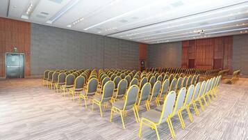 A large conference room with rows of chairs and a podium.