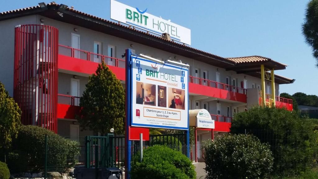 Un hotel con fachada roja y blanca, un cartel publicando habitaciones para 1 a 4 personas, y una zona de recepción.