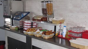A buffet counter with various food items, including bread, pastries, and condiments. - Brit Hotel Essentiel Sète Balaruc (Balaruc-le-Vieux)