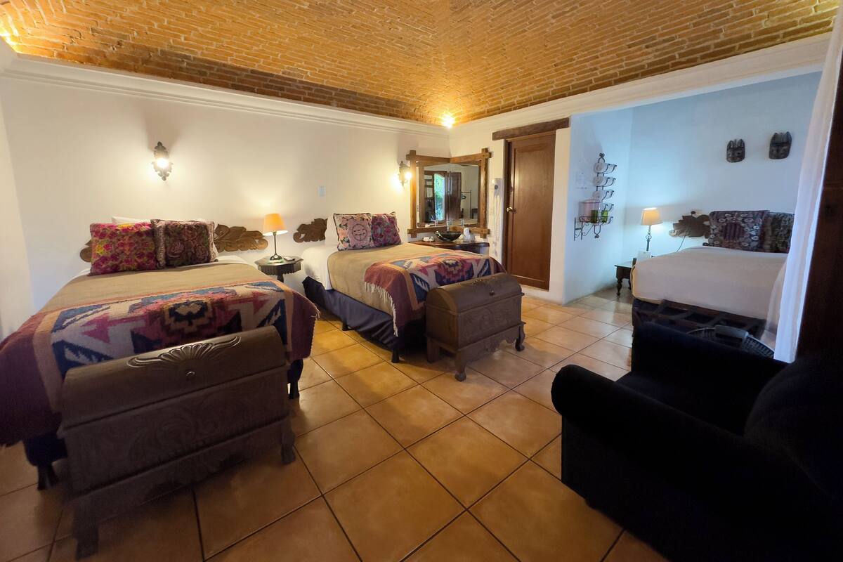 Ein Zimmer mit zwei Betten, einer Kommode, einem kleinen Tisch und einem Stuhl.