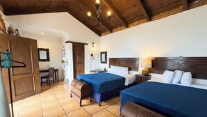 A room with two beds, a wooden ceiling, a desk with a chair, and a door. - Naif Boutique Hotel (Antigua Guatemala)