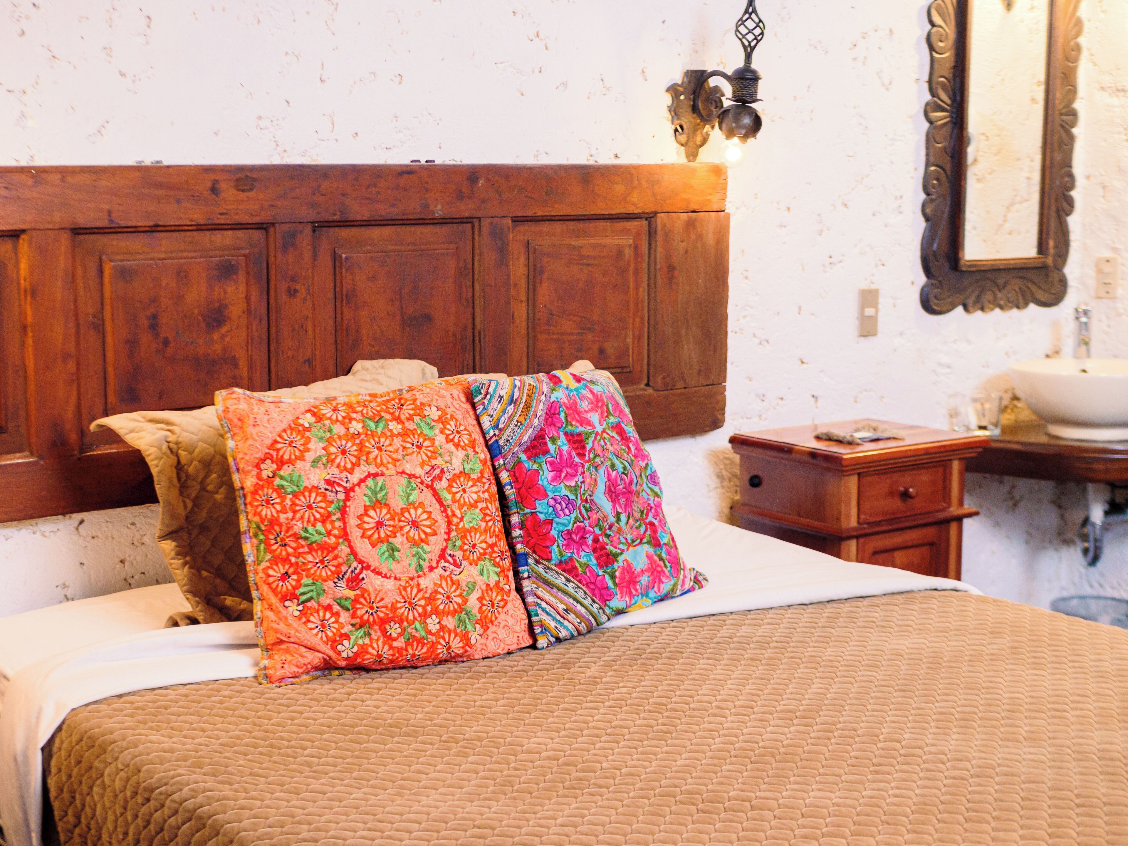 A bed with a wooden headboard, a bedside table, and a nightstand.