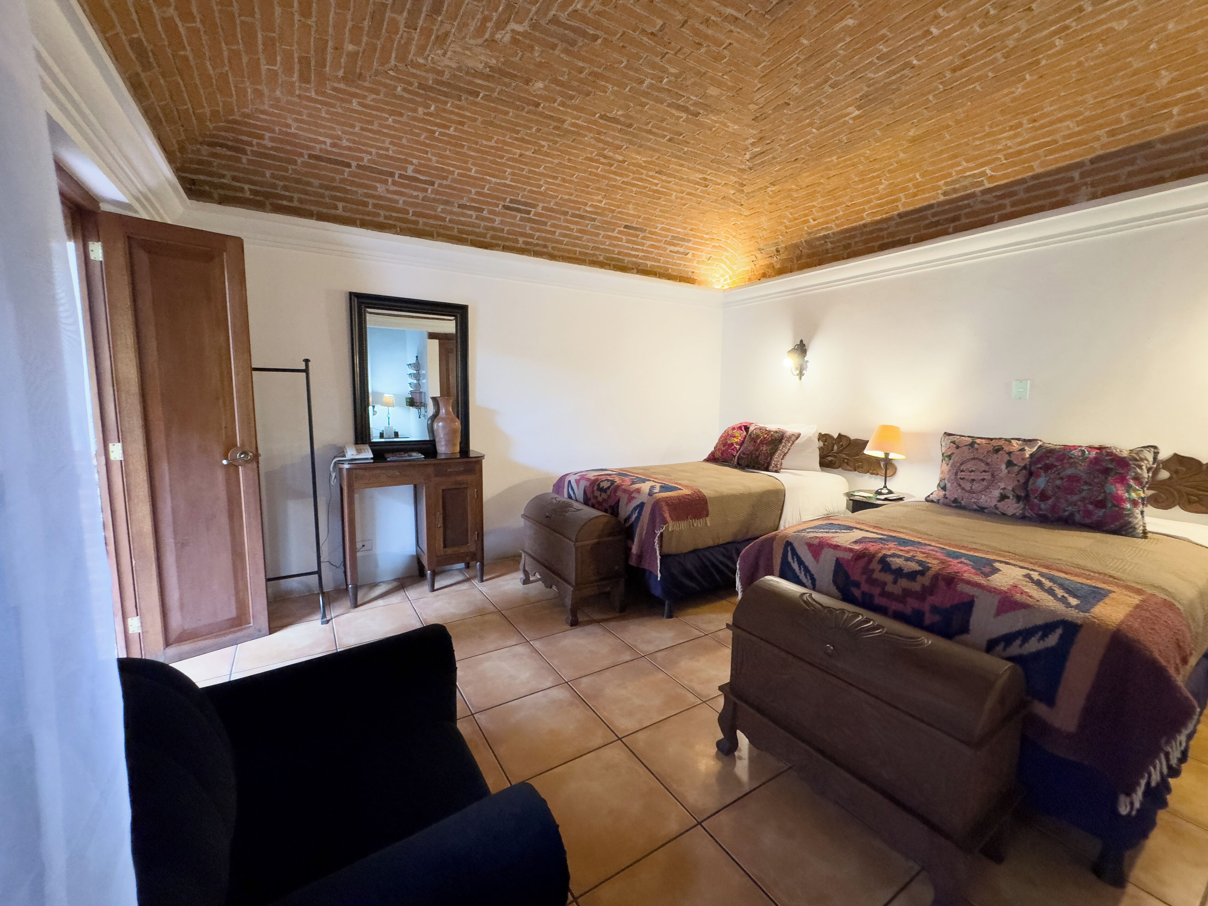 Una habitación con dos camas, un escritorio y una silla.