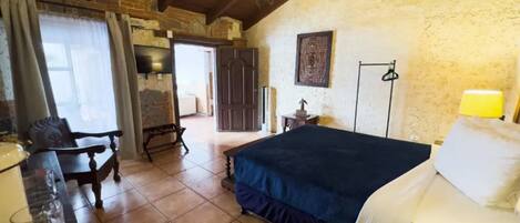 A rustic room with a bed, wooden furniture, and a chandelier.