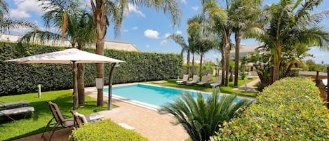Una piscina al aire libre, tumbonas