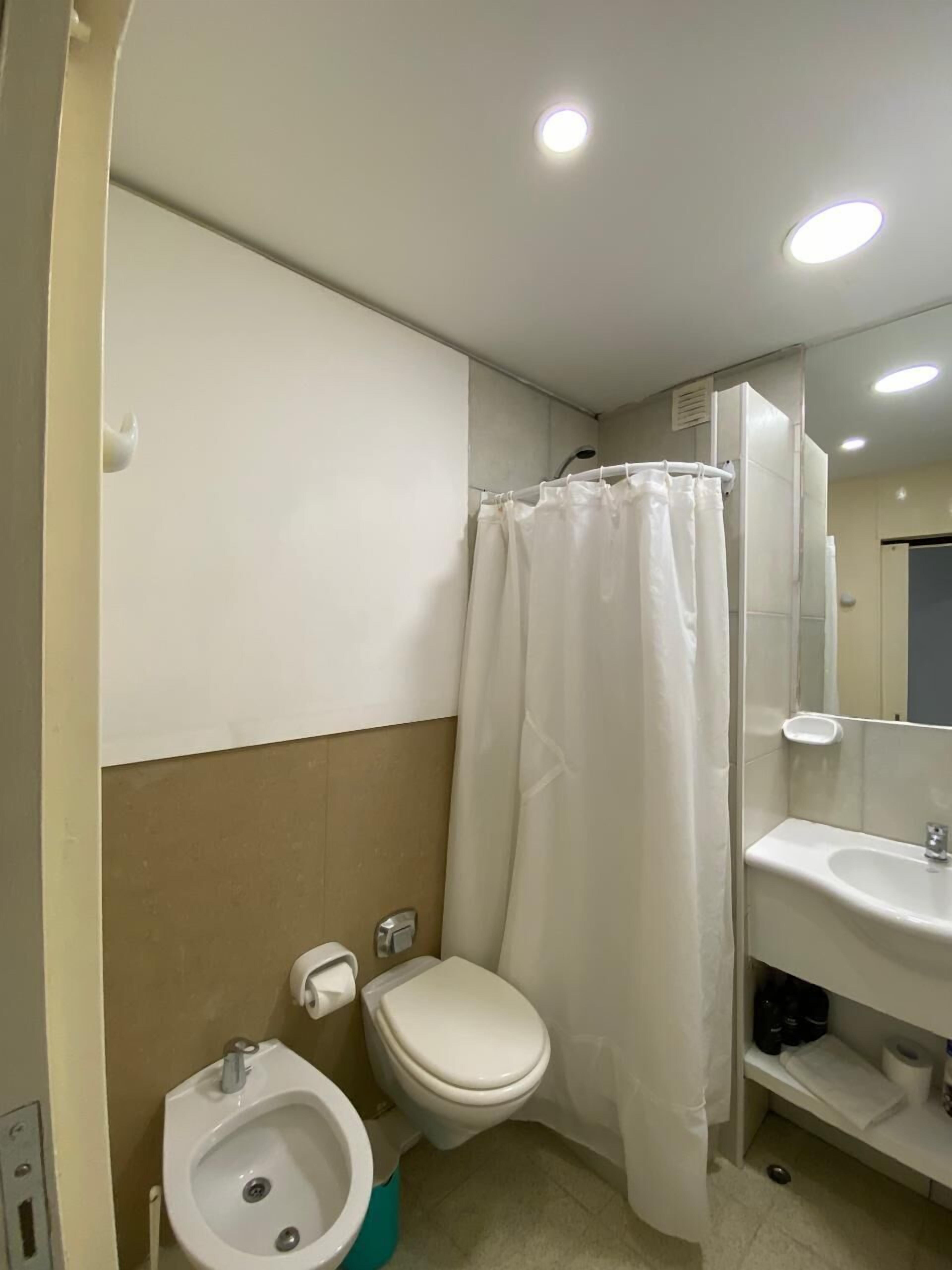 A bathroom with a toilet, bidet, and sink.
