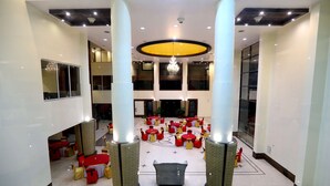 A spacious lobby with a central seating area, large windows, and a chandelier.