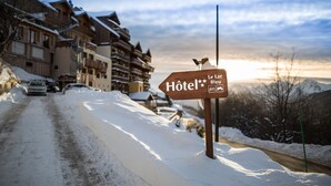 Une enseigne en bois portant l’inscription « Le Lac Bleu Hôtel », indiquant la présence d’un hôtel.