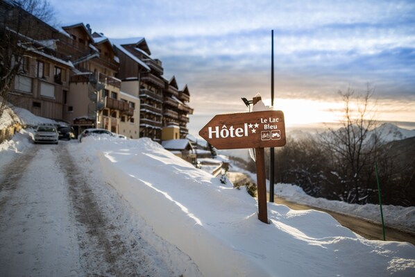 Une enseigne en bois portant l’inscription « Le Lac Bleu Hôtel », indiquant la présence d’un hôtel.