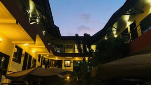 A multi-level building with outdoor seating areas and a central atrium. - Détente Hôtel (Abidjan)