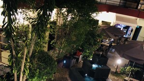 An outdoor patio area with a water feature, seating, and ambient lighting. - Détente Hôtel (Abidjan)