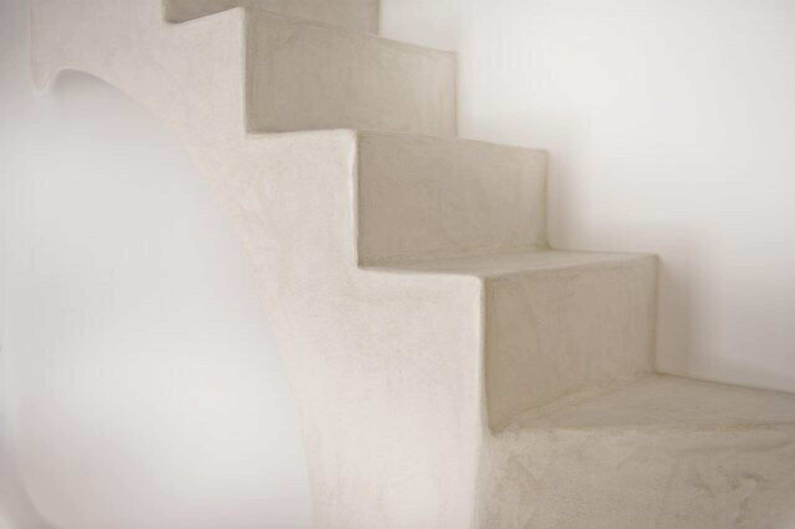 A set of white, concrete stairs leading up to a landing.