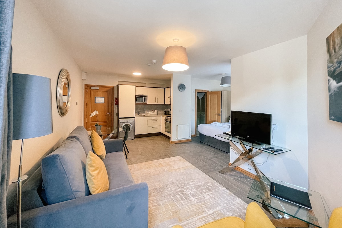 A modern living room with a sofa, a glass coffee table, and a television.