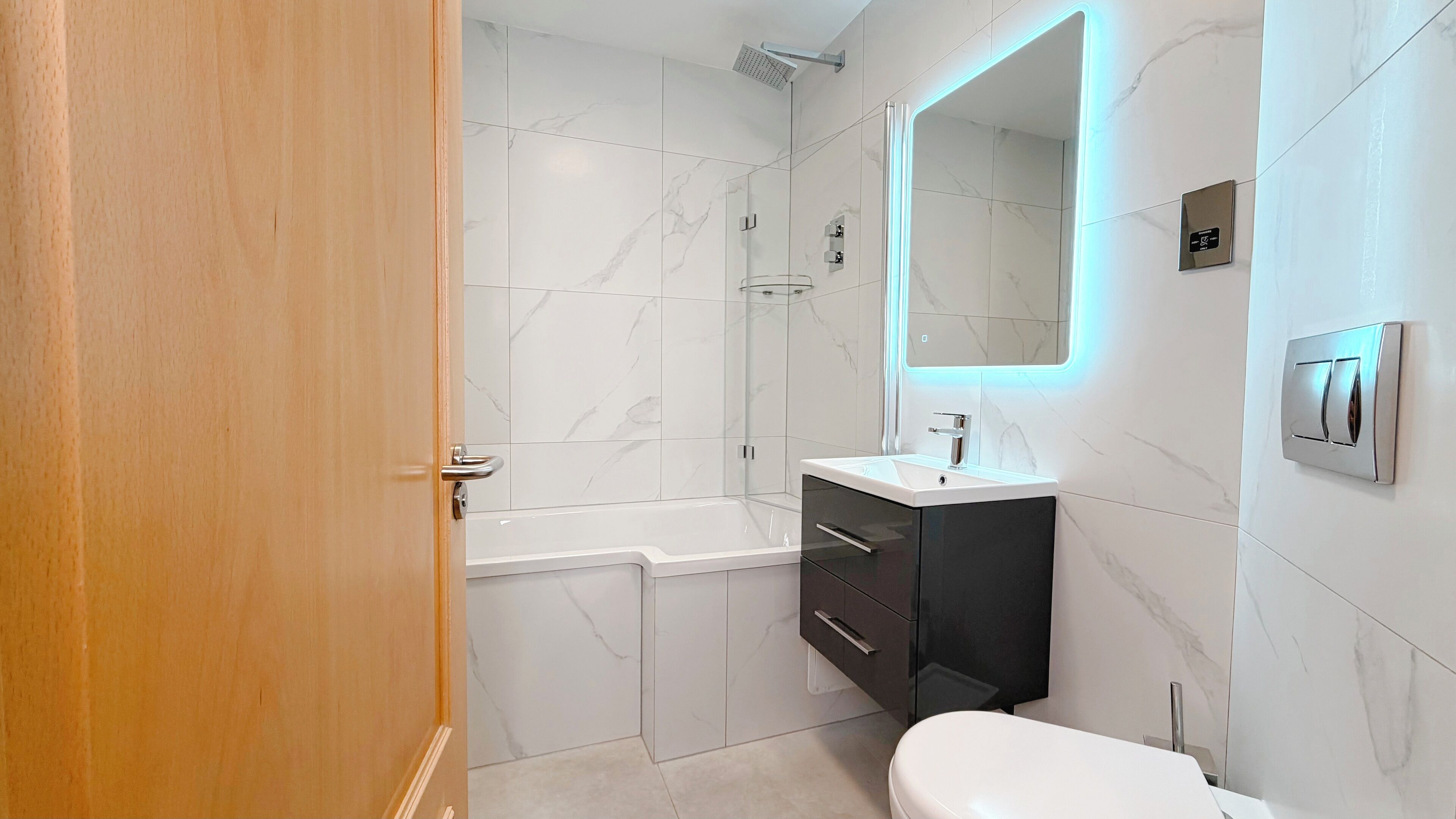 A modern bathroom with a shower, toilet, and vanity.