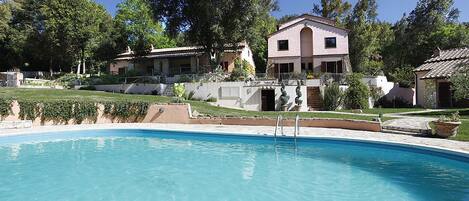 Piscine extérieure en saison, parasols, chaises longues