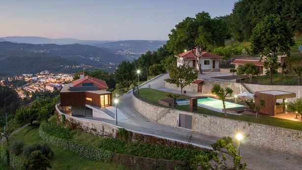 A hillside residential area with modern houses, a swimming pool, and a view of a distant town. - Quinta do Fontelo (Vouzela)