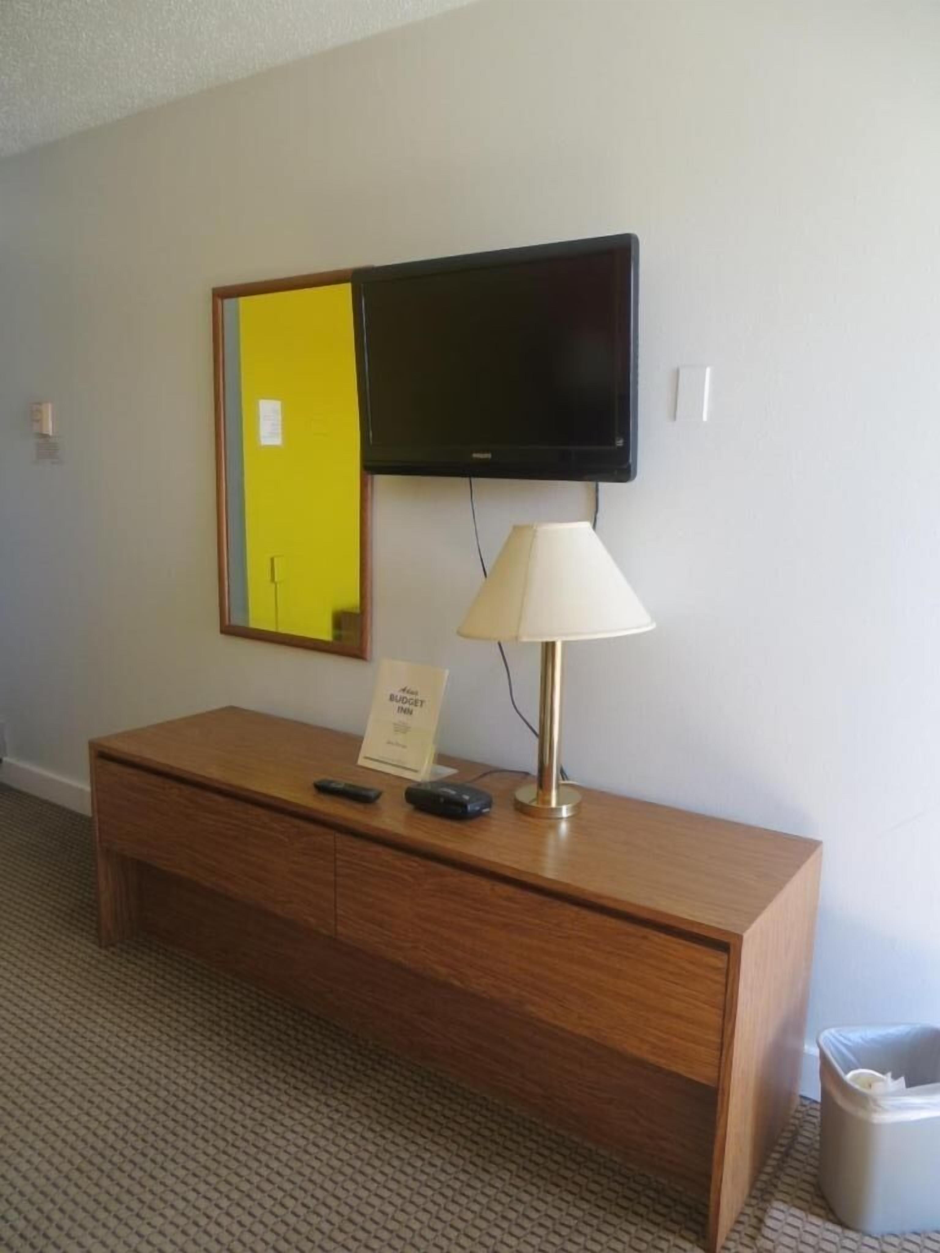 A room with a wooden cabinet, a yellow folder, a black electronic device, and a white lamp.