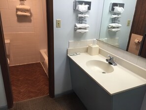 A bathroom with a sink, mirror, towel rack, and toilet.