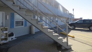 A multi-story building with a staircase leading to the upper floors. - Adair Budget Inn (Adair)