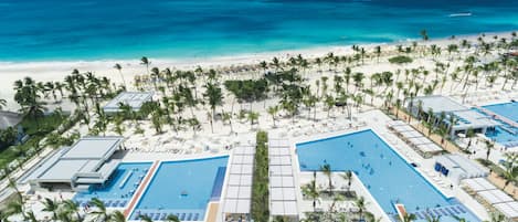 Alberca al aire libre, sombrillas en la alberca y camastros