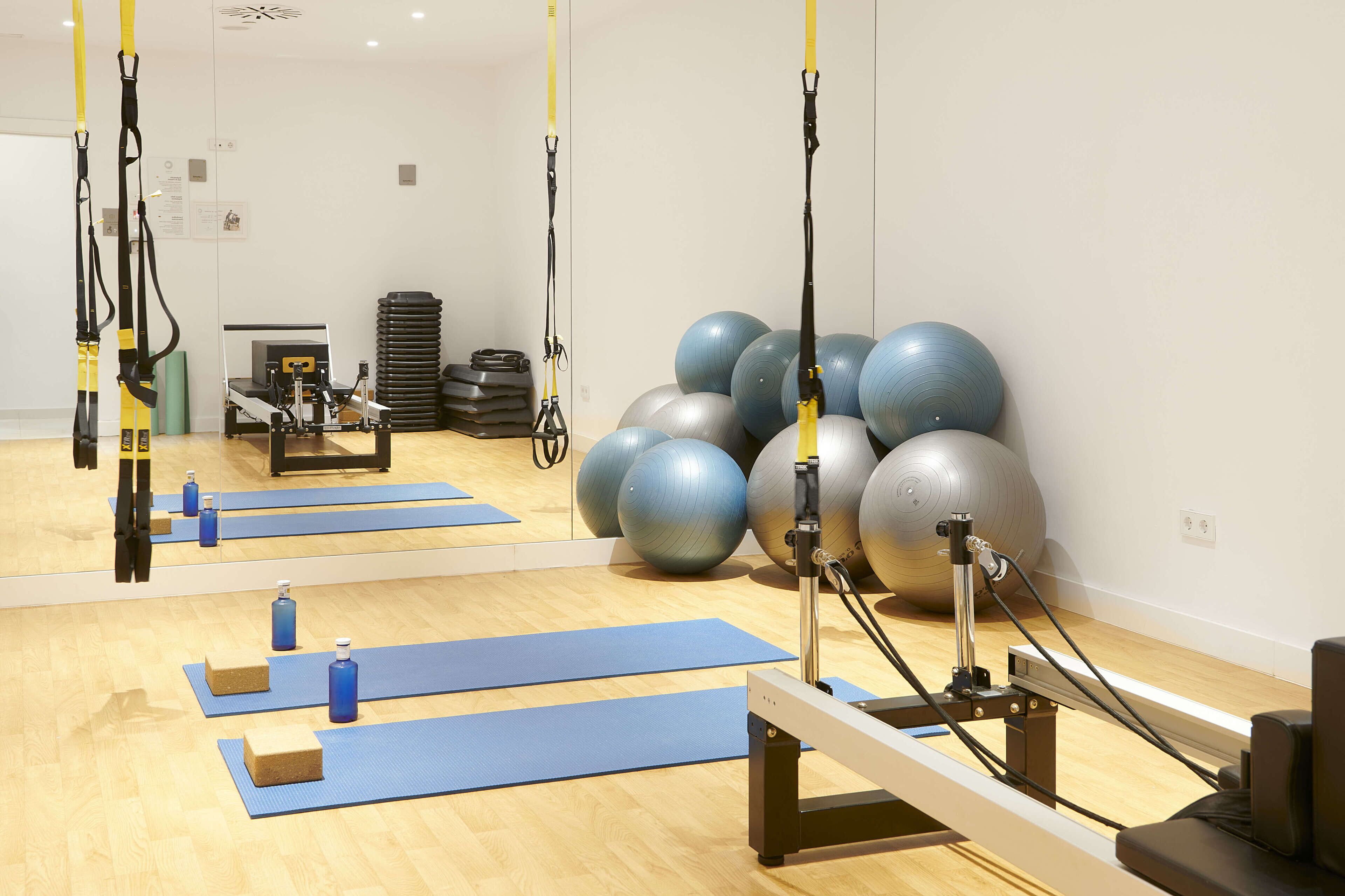 A fitness studio with exercise equipment, yoga mats, and exercise balls.