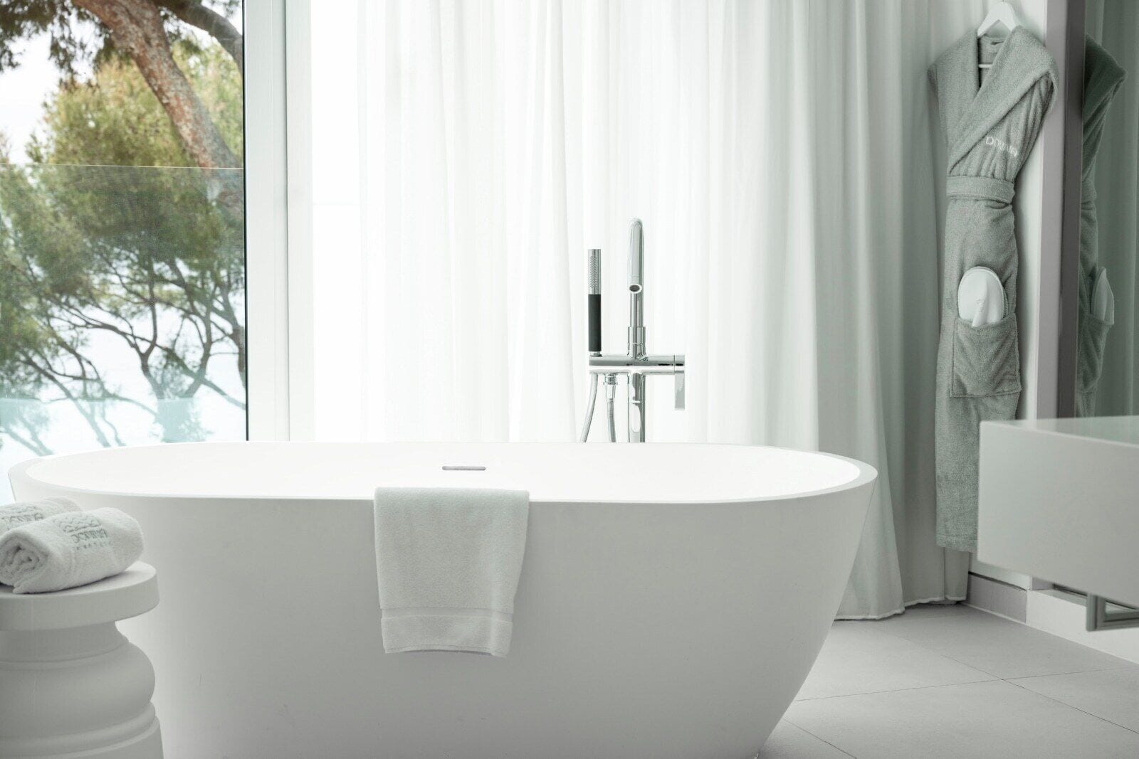 A modern bathroom with a freestanding bathtub, a toilet, and a shower area.
