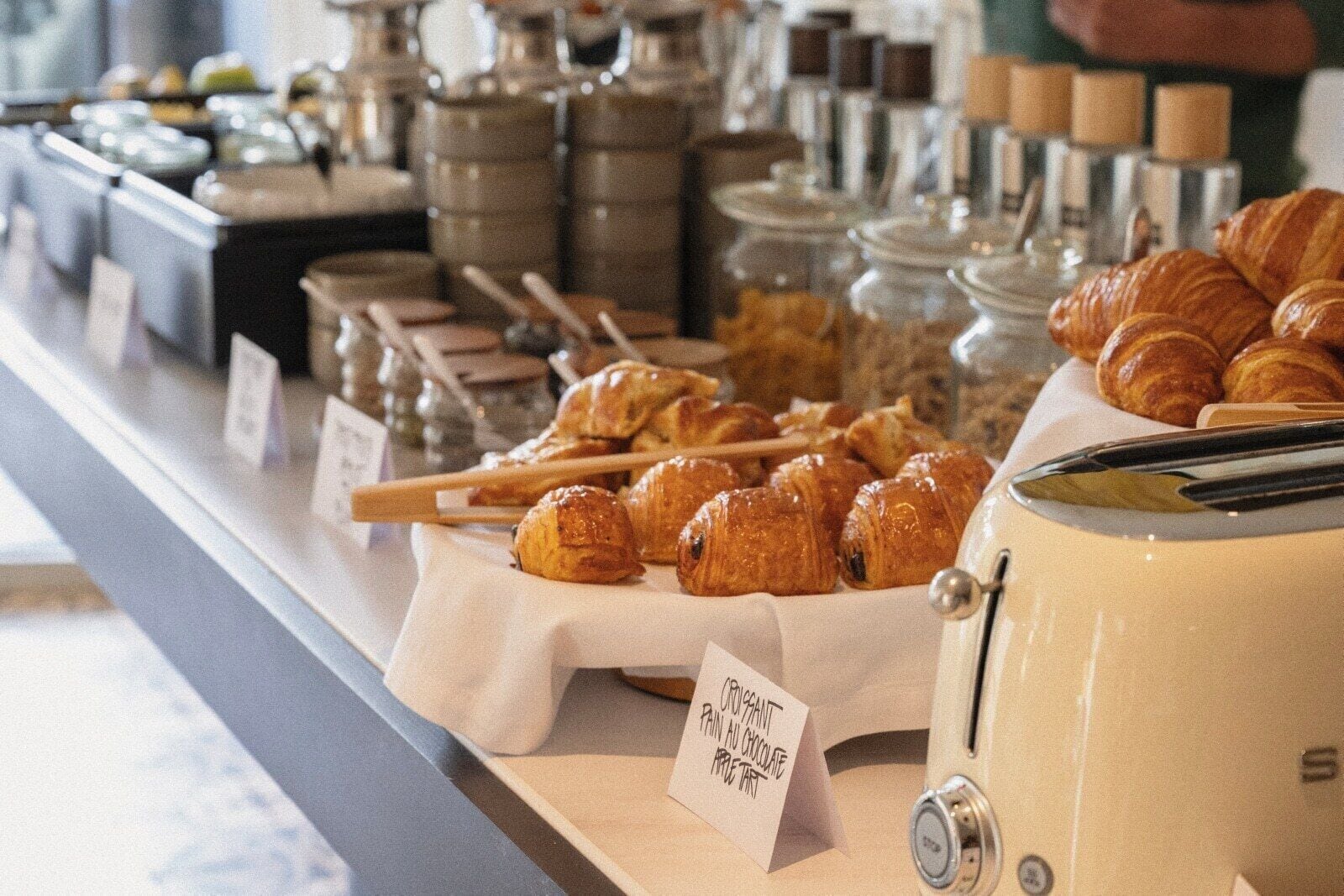 Une vitrine de boulangerie présentant des croissants et une pancarte indiquant qu'on y vend des tartes aux pommes au chocolat.