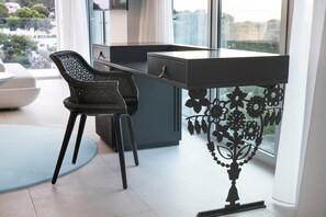 A modern office space with a desk, two chairs, and a decorative metal railing with floral patterns.