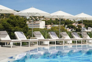 Seasonal outdoor pool, a natural pool, pool umbrellas, sun loungers