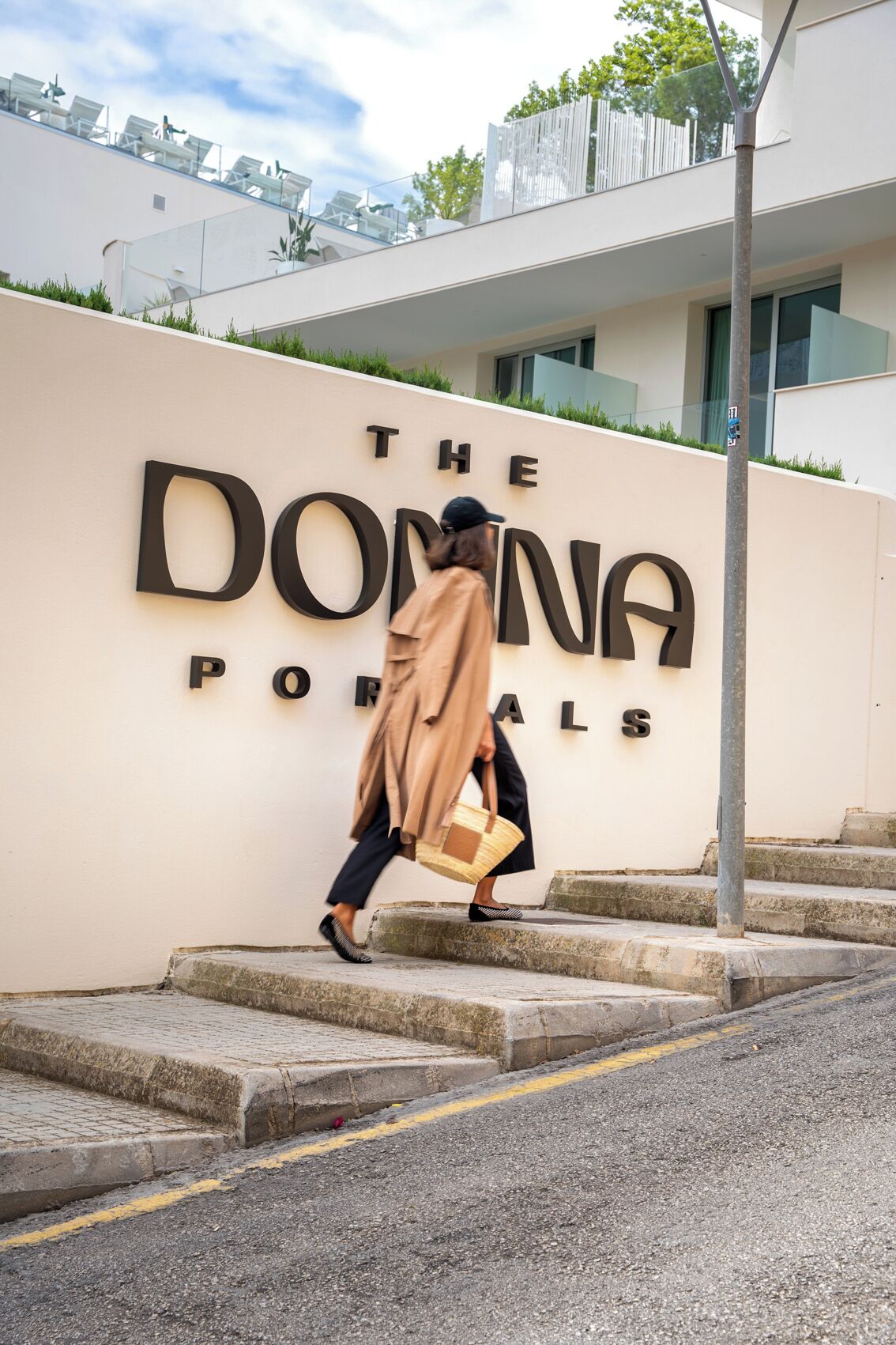 Una persona caminando hacia un edificio con un letrero que dice "THE DONNA PORTALS".